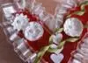 A closeup of the flowers, ribbon,  and stems on the heart shaped box...
